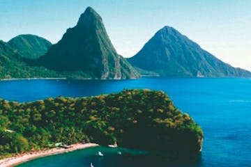 a body of water with Pitons in the background