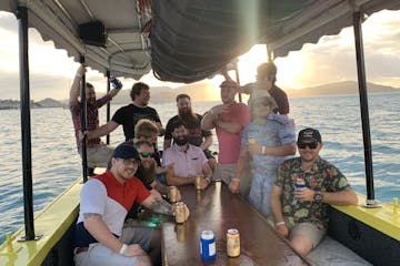group posing on boat during sunset