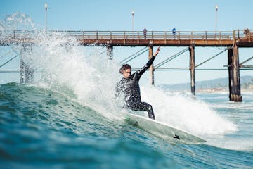a man is surfing on a bridge over a body of water