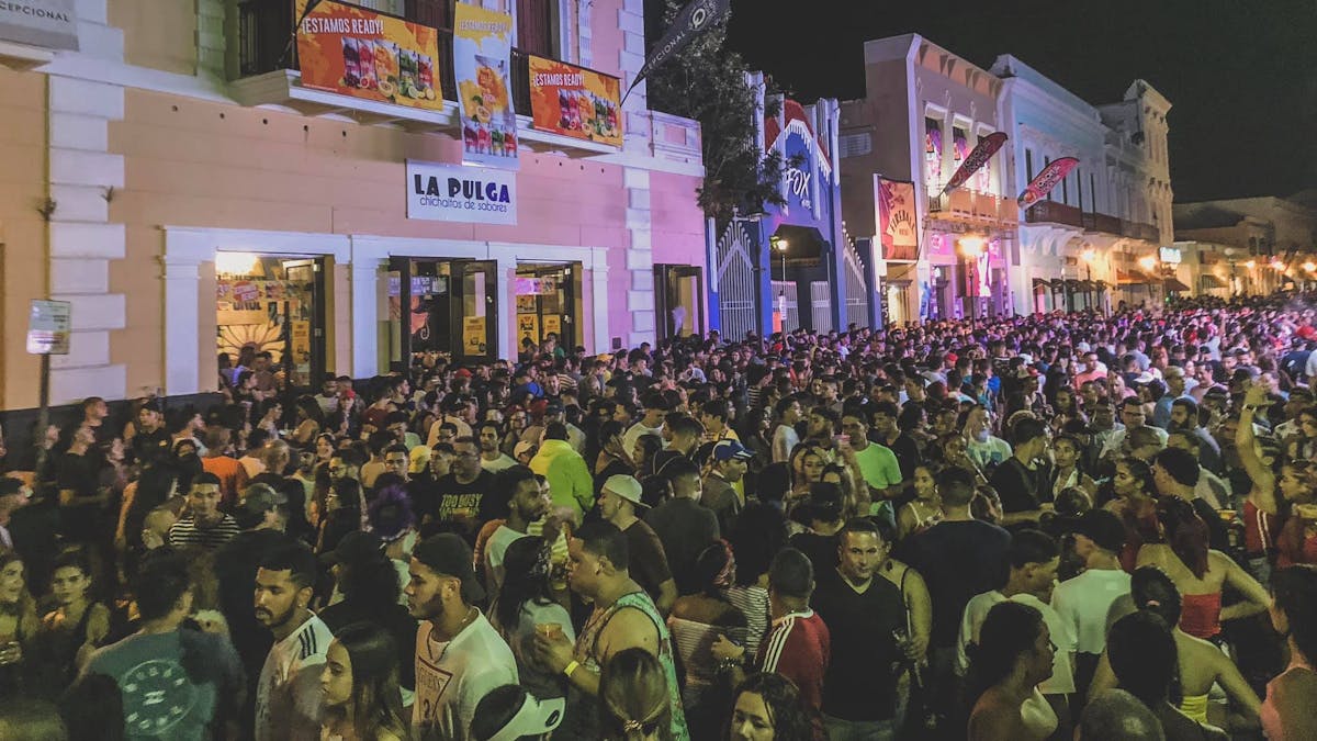 A crowd of people gathered outside a bar in San Juan