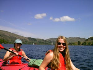 Two women kayaking on Ullswater on a sunny day