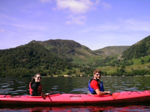 Two people in a small boat on Ullswater in The Lake District
