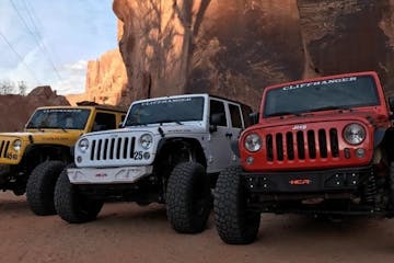jeeps parked in front of red rocks