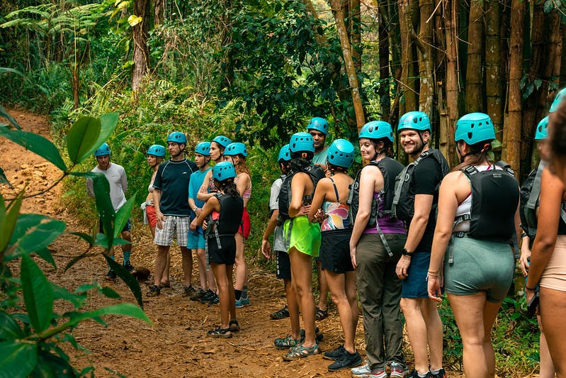 a group of people on a hike in El Yunque wearing safety helmets and posing for the picture