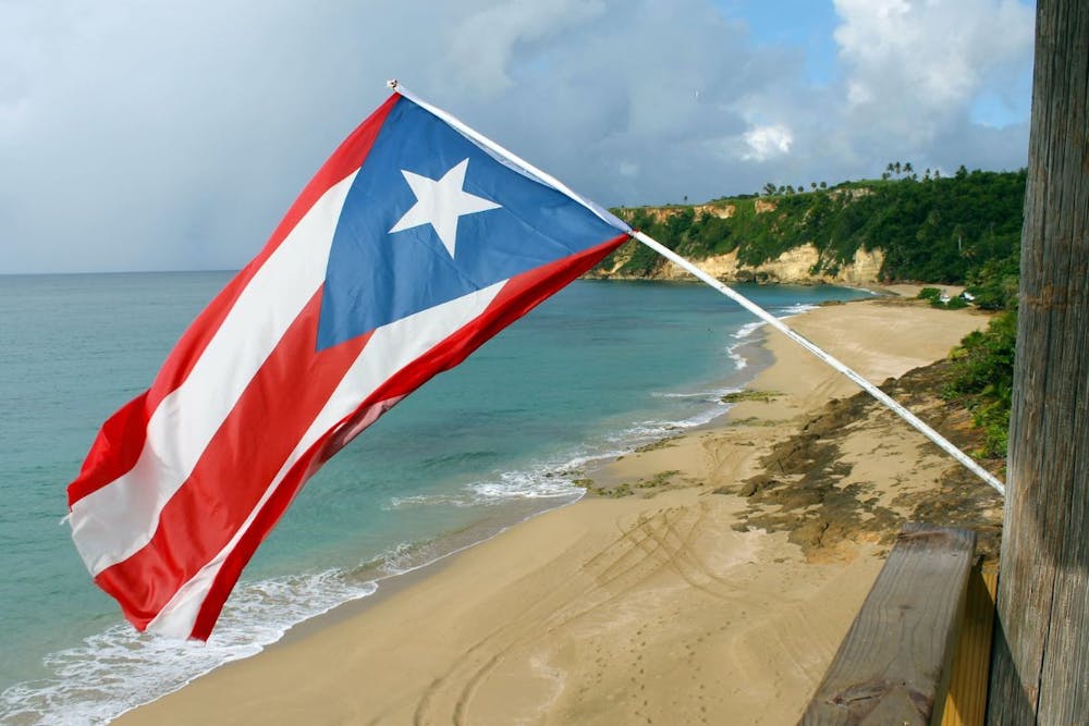 a flag flying by a beach in puerto rico