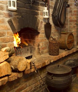 a stove top oven sitting inside of a stone building
