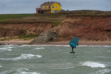 a man carrying a surf board on a body of water