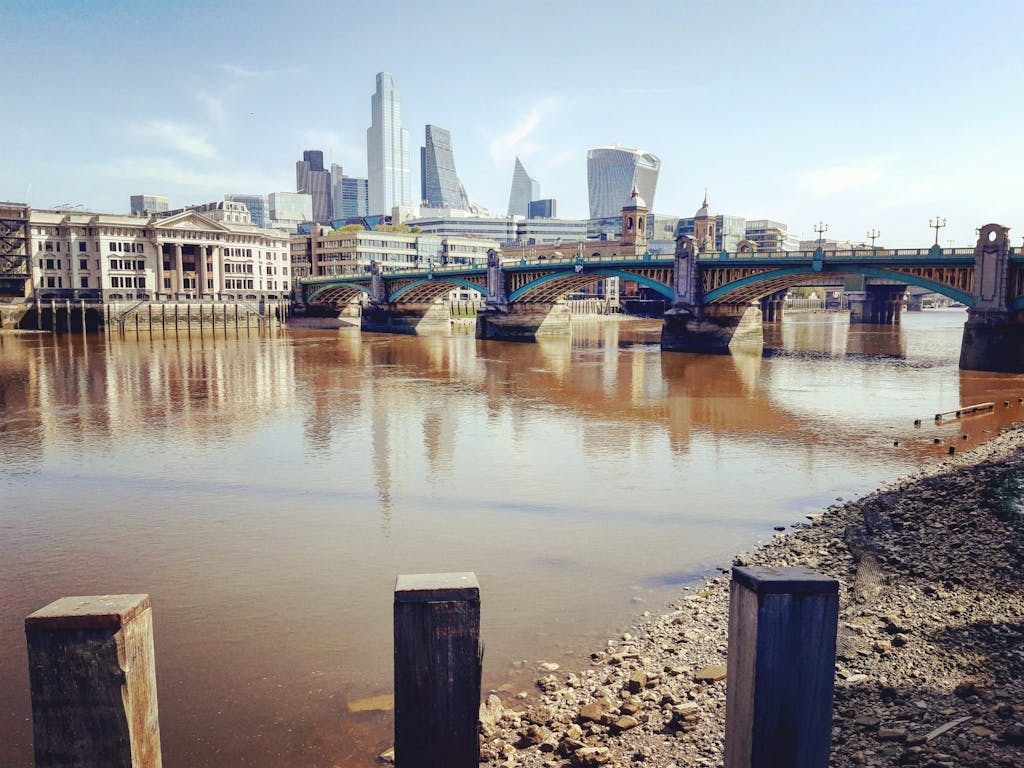 River Thames foreshore: From Shakespeare’s Globe across the River Thames; Southwark Bridge and Vintners Hall in the foreground looking towards the City of London with views of the Walkie Talkie, the Scalpel and the Cheesegrater - London Cab Tours