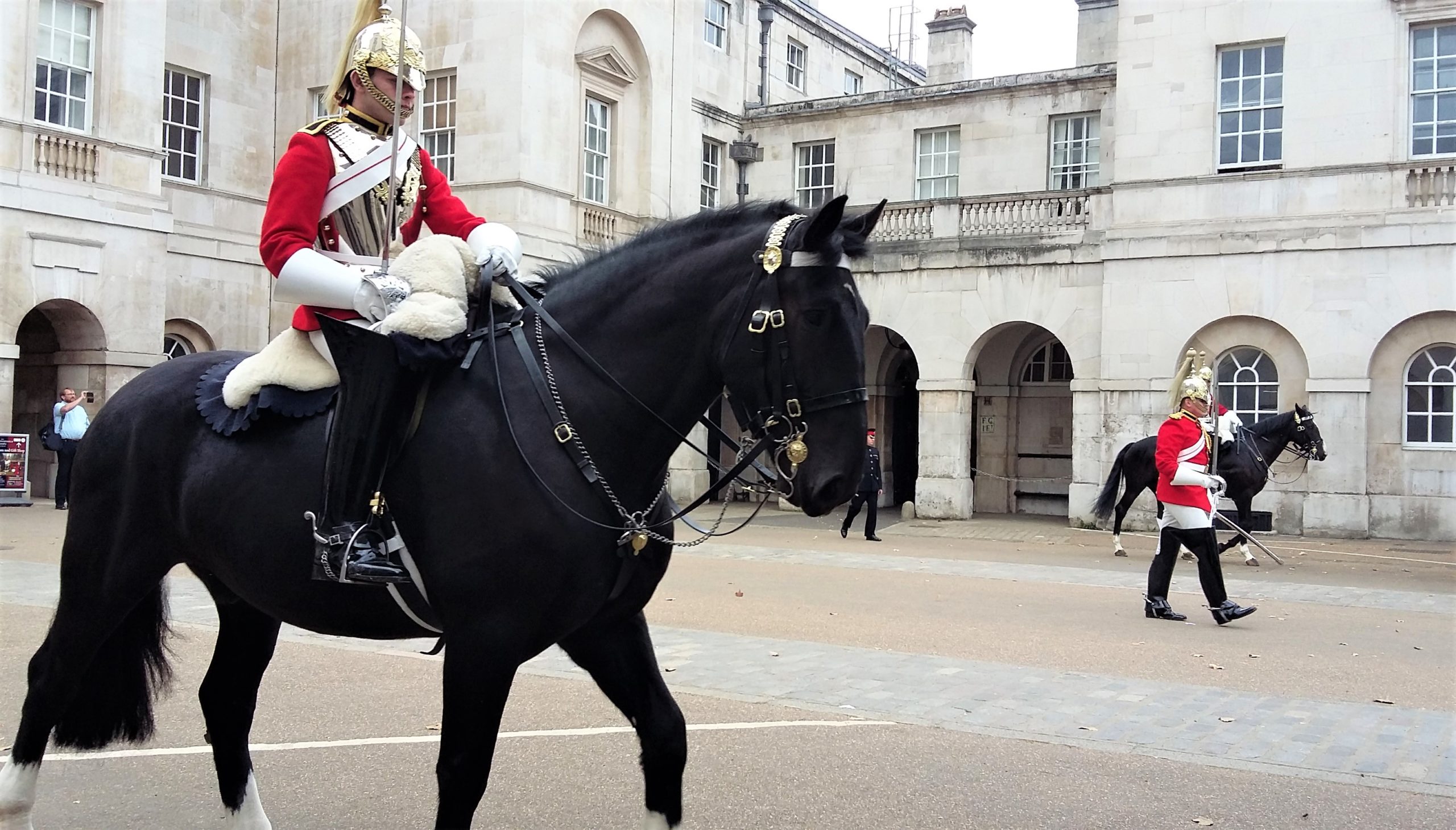 a person riding a horse in front of Horse Guards