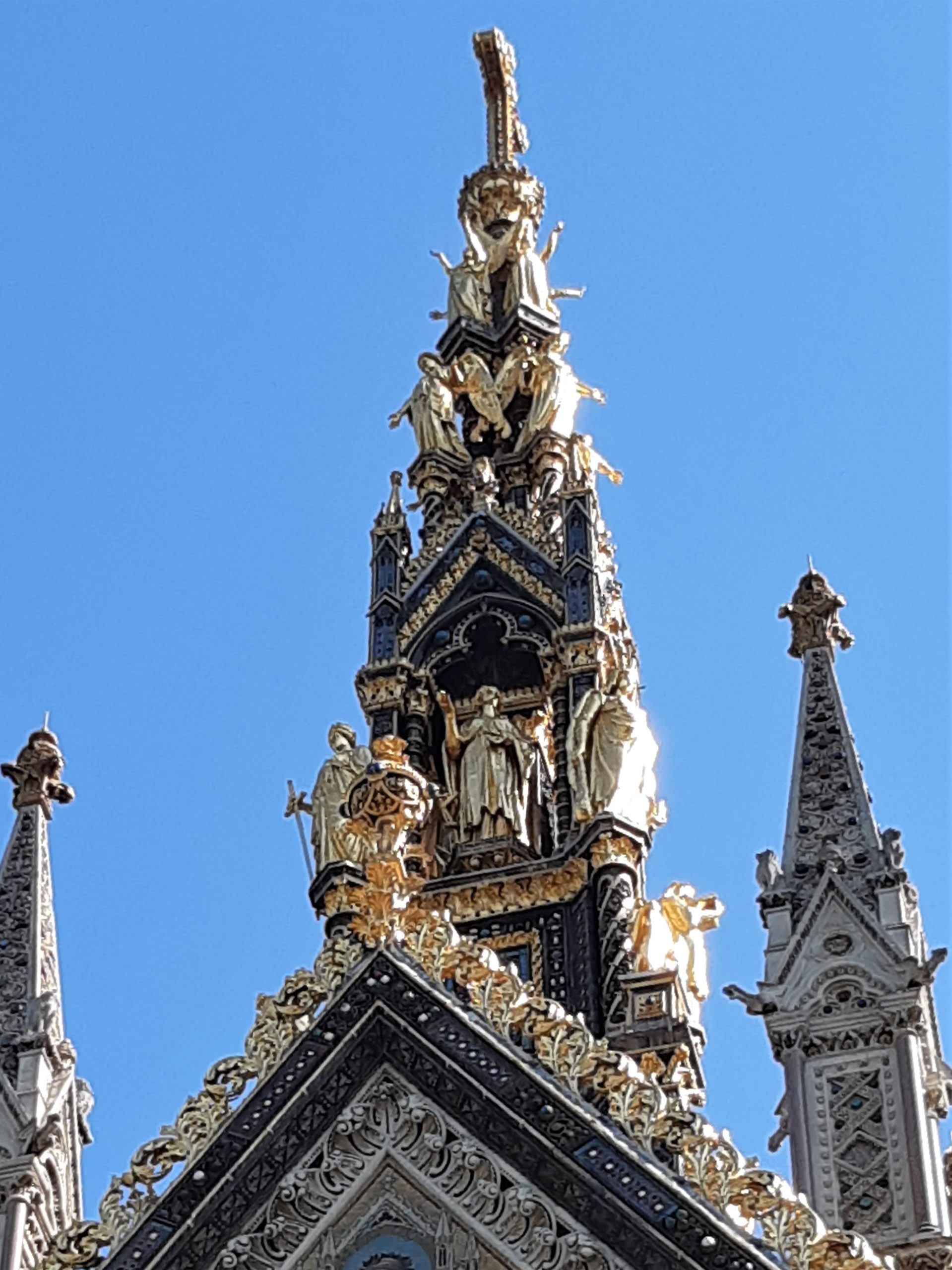 a large clock tower in front of a statue