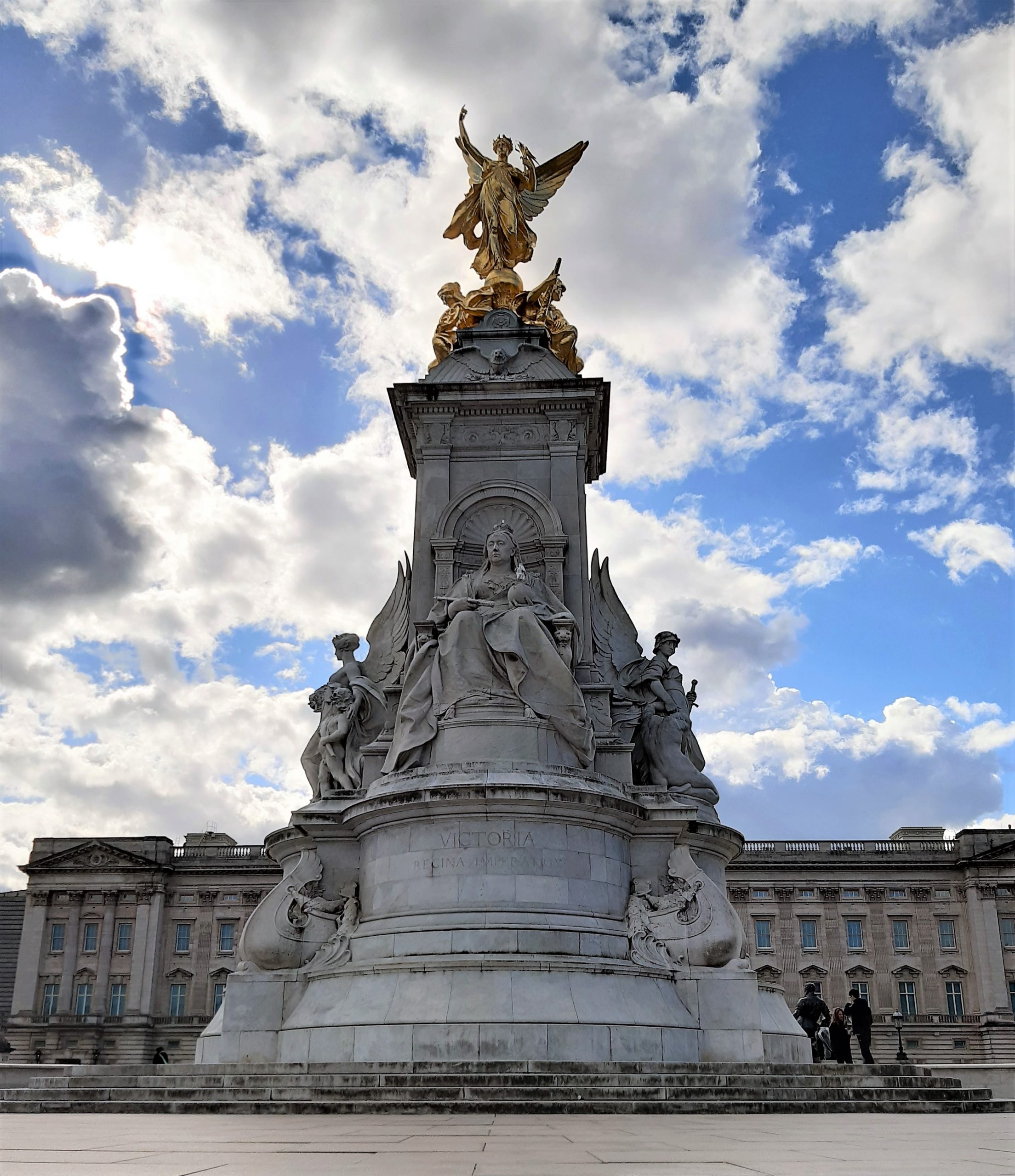 a large clock tower in front of Victoria Memorial, London