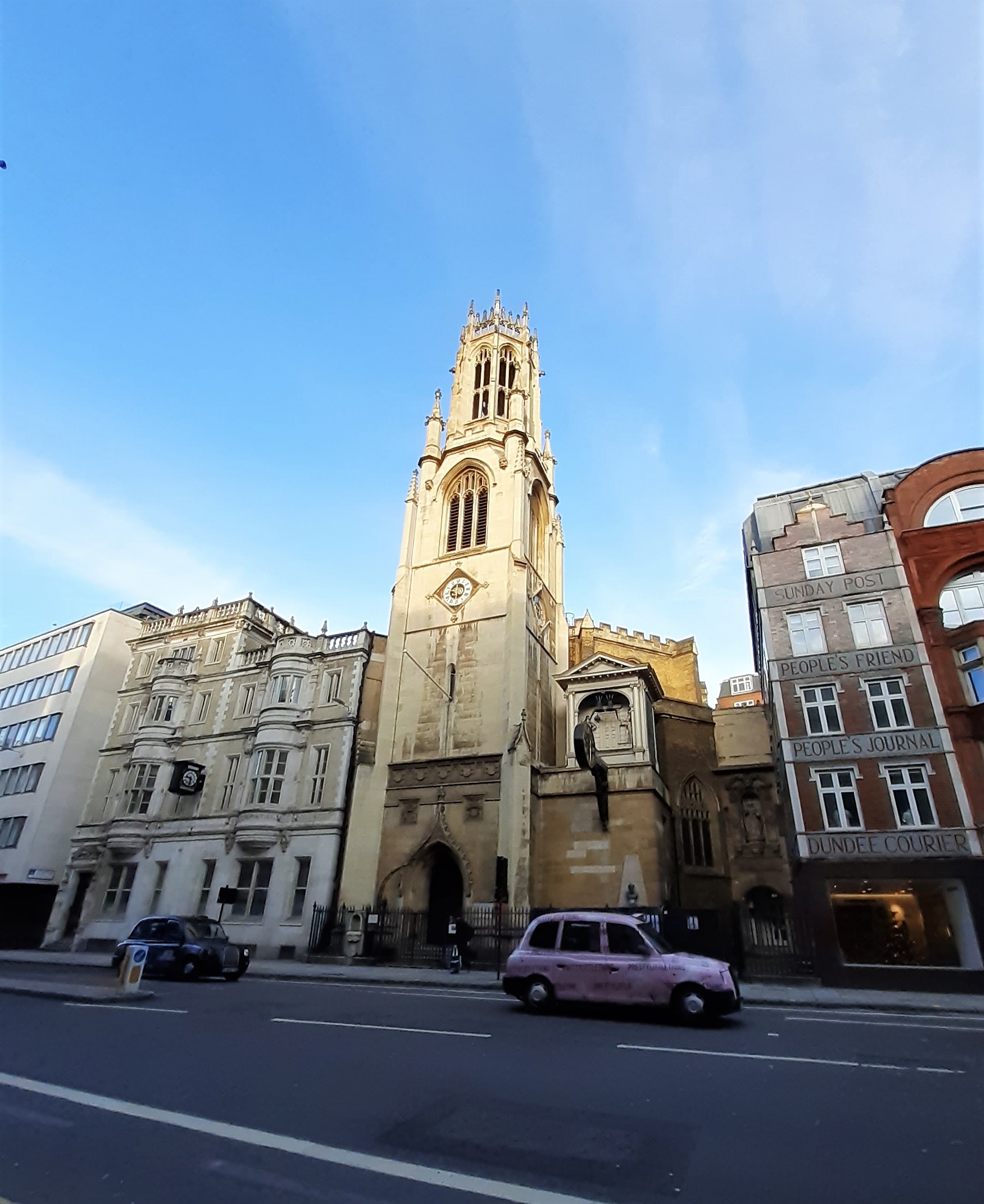 a large building with a clock on the side of a road