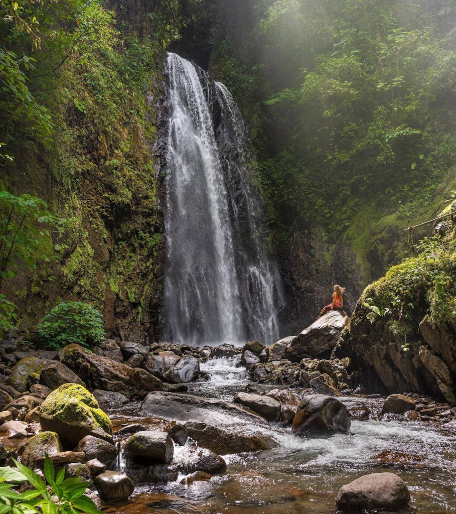 a traveler standing next to a waterfall at El Tigre Waterfalls
