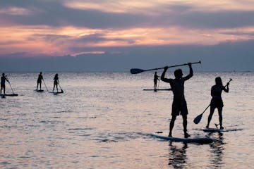 doing paddle board during sunset