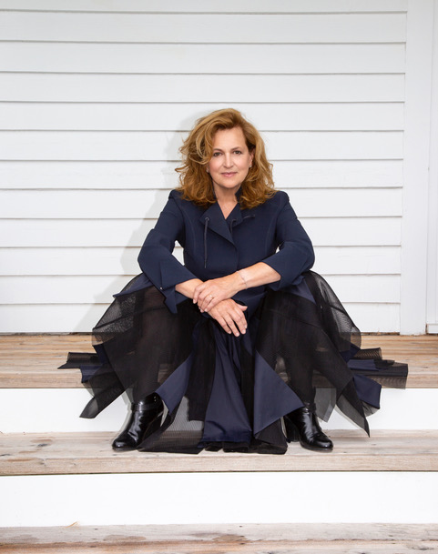 a woman sitting on a bench posing for the camera