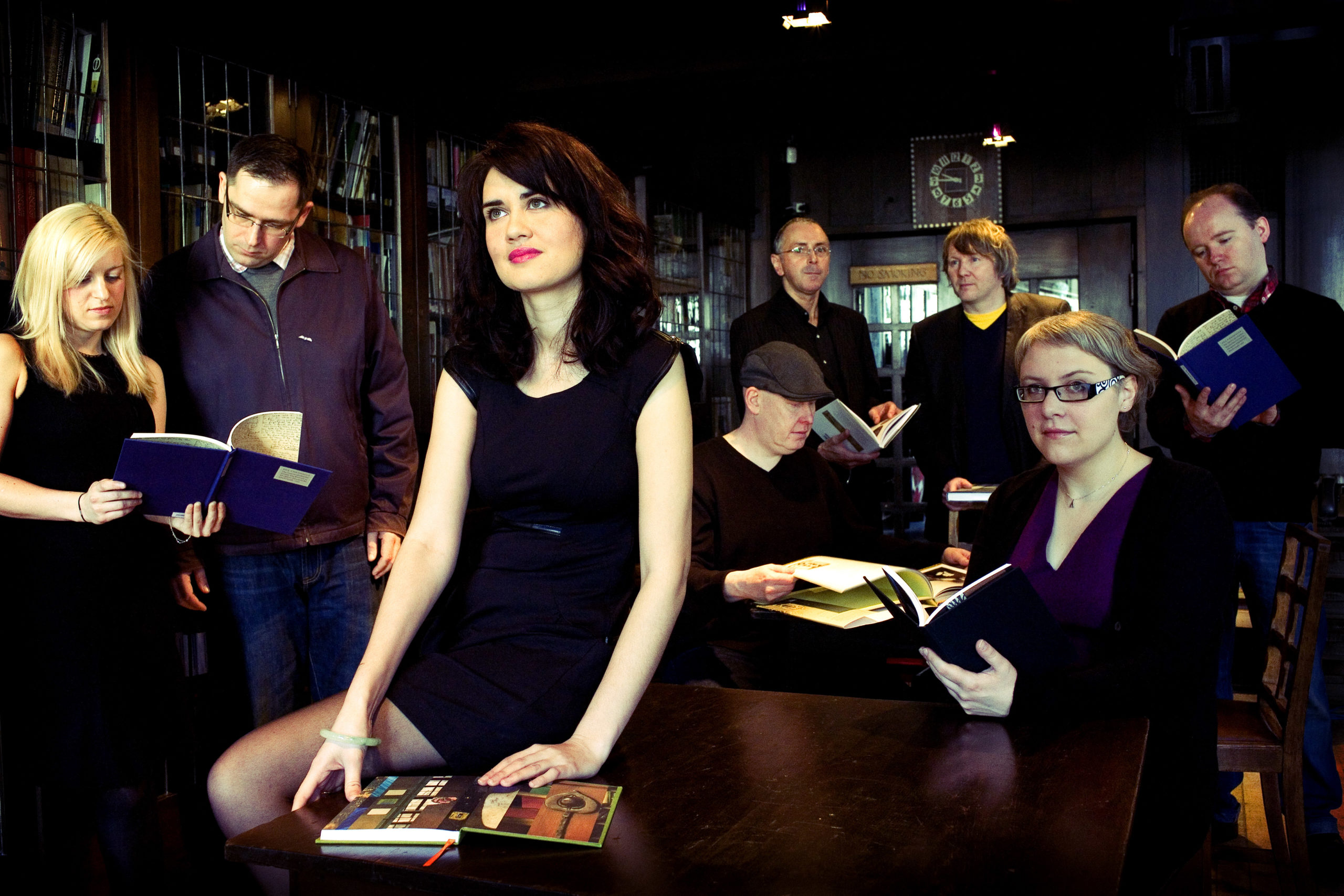 a group of people standing on top of a cutting board with a cake