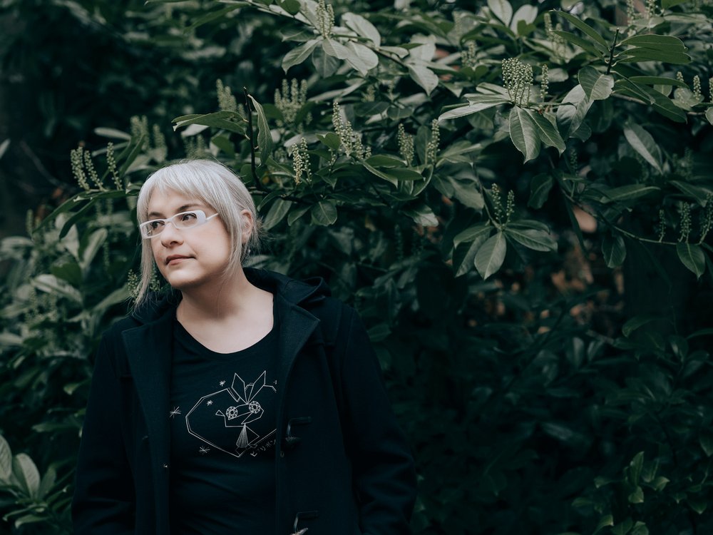 a person standing in front of bushes