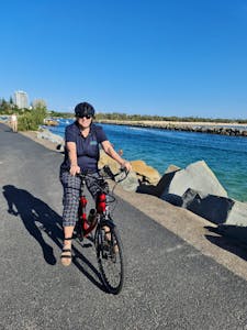 Tracey riding a e-bicycle Pt Cartwright Rock Wall 