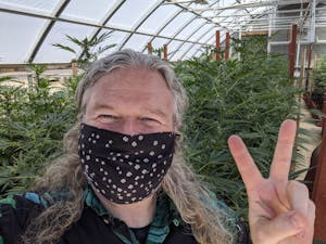 A cannasseur throwing up a peace sign on one of the pot farms in California's Emerald Triangle
