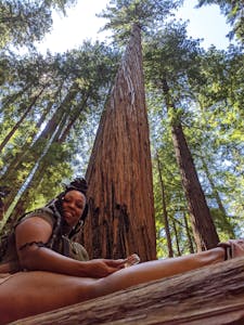 A woman in the giant redwoods on a 420 tour after imbibing