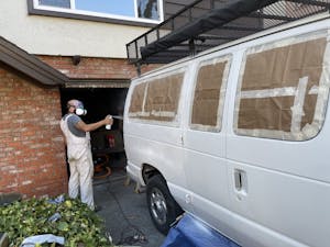Man spraying primer on a van
