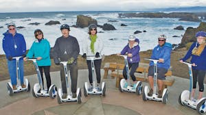 a group of people son Segways on the beach