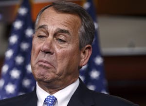 Corporate cannabis lobbyist John Boehner wearing a suit and tie in front of American flags