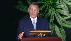 John Boehner at a podium with pot leaves behind him