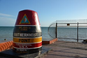 a bottle of water with Southernmost point buoy in the background