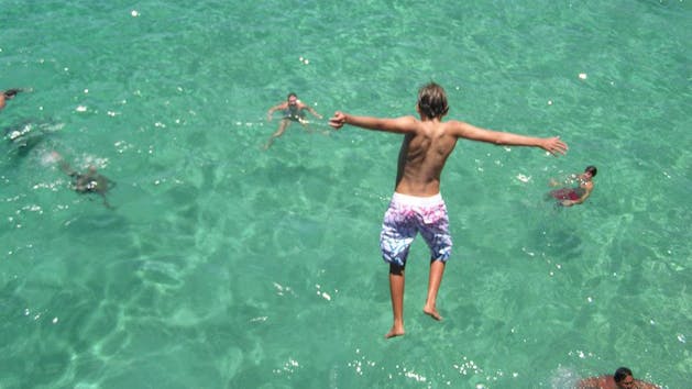 Boy jumping into ocean