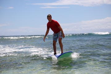 guy in red shirt surfing in kauai