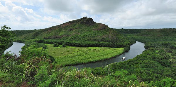 a river with a lush green hillside