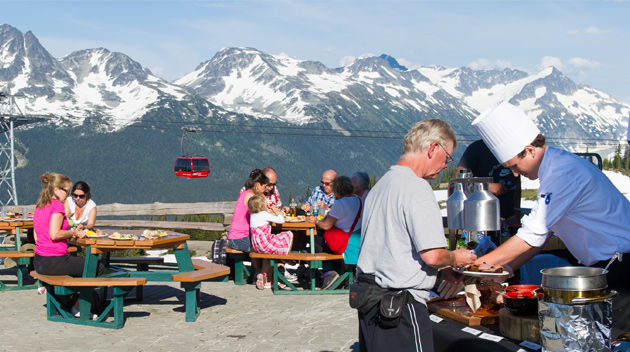 People enjoy eating outdoors under a gondola