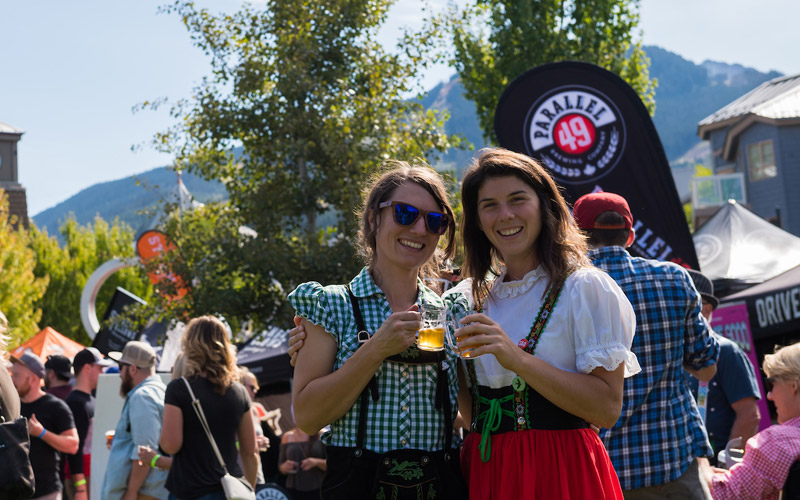 Two women in German attire, enjoying beer