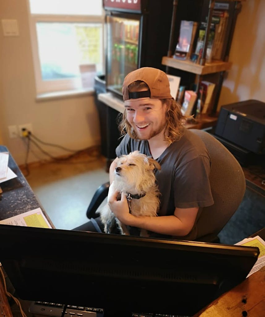 a person sitting at a desk with a dog