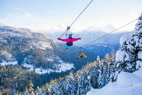 Two people zipline with Superfly in Whistler in Winter