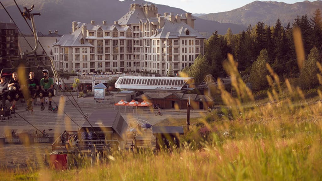 A hotel in Whistler at the base of the mountain, looking through the grass.
