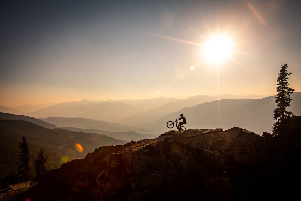 A mountian landscape, with the Whistler bike park and a biker in the forefront
