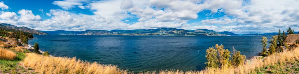 a body of water with a mountain in the background - okanagan, bc