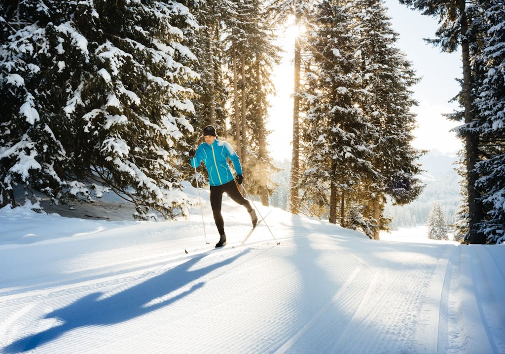 a person is cross country skiing on a snow covered slope