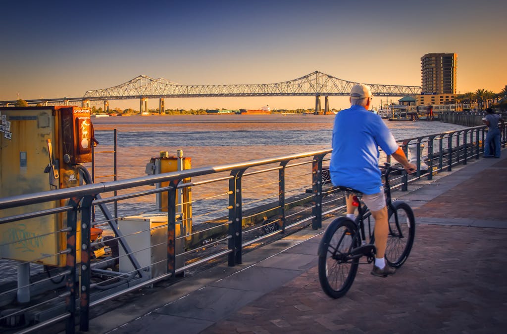a person riding a bicycle on a bridge over a body of water