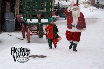 santa and elf walking by the train