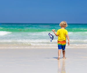 a young boy standing on a beach