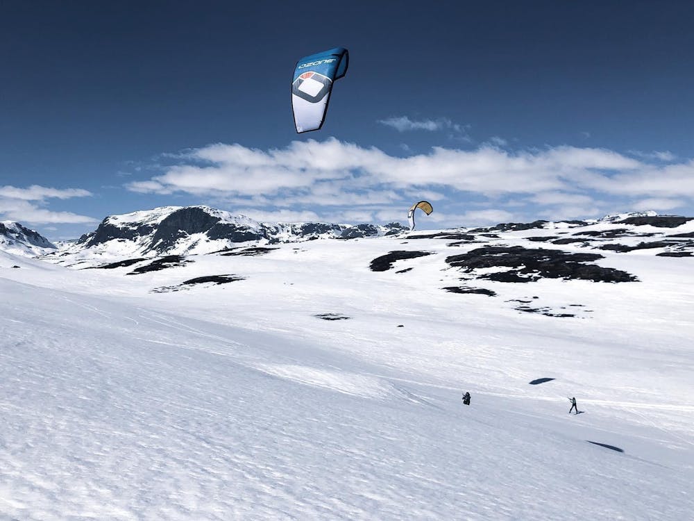 a person flying through the air on a snow covered slope