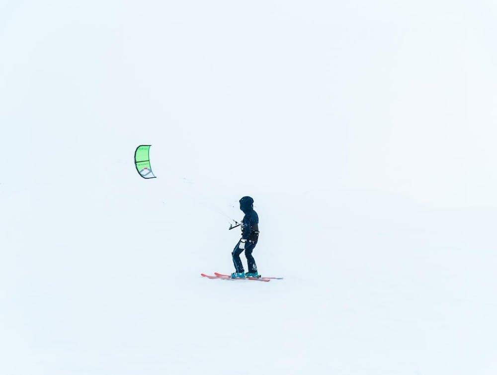 a person flying a kite in the snow