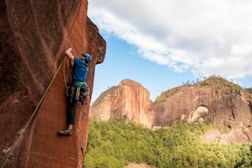 a rock climber climbs a steep sport climbing route in Liming, Yunnan, China