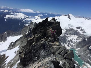 a climber on a guided trip up Forbidden Peak traverses near the summit