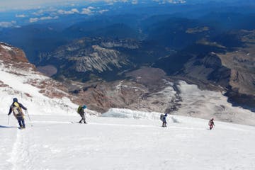 a group of people riding skis down a snow covered mountain