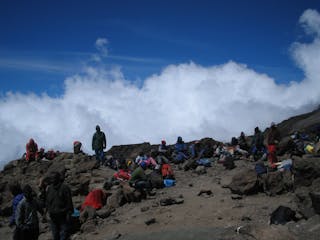 trekkers, guides, and local support staff rest high on Kilimanjaro's slopes