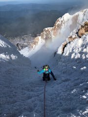 a climber on a steep snow chute on Mount Hood during a guided climb